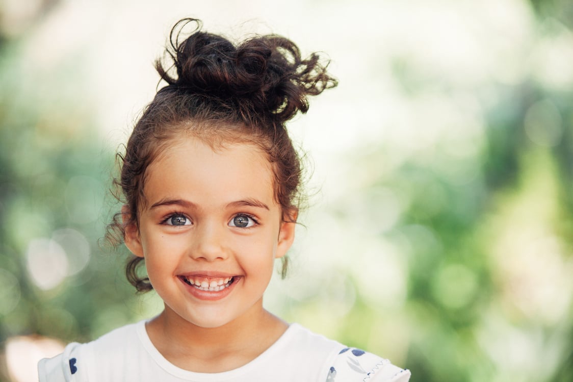 Happy toddler girl smiling outdoors